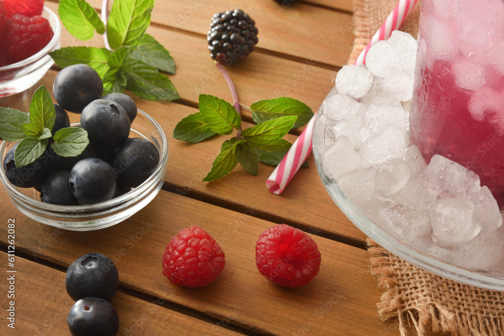 Wall mural detail of berry drink with ice and fruit around