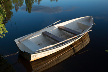 Rowboat anchored in a calm lake in Sweden at sunset