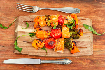 Fish salmon skewers on wooden board.
