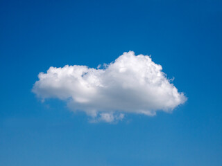 Single white cloud over blue sky background. Fluffy cloud shape photo