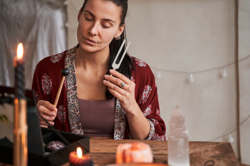 Calm brunette woman burning candles at retreat center while enjoying her hobby