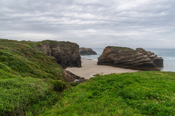 Catedrales Beach in Ribadeo Galicia de Lugo Spain. Sea nature vivid landscape. Stone arches. Scenic cliffs view. Beach at low tide. Coast in northern Spain. Tourist place.