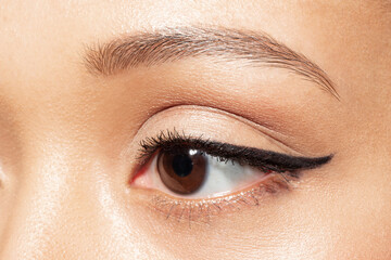 Close up of brown eye of young woman looking aside. Closeup of mixed race ethnicity female eye with...