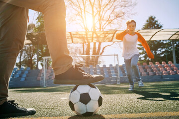 Father and Son play football on stadium outdoors, Happy family bonding, fun, players in soccer in...