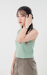 Portrait isolated cutout studio shot of Asian young cool female teenage fashion model with pigtails braids hairstyle in casual trendy shirt shorts standing posing look at camera on white background