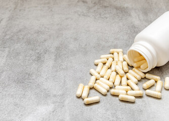 many pills tablets capsules spread on surface in woman hand or bottle.wooden spoon in row with...