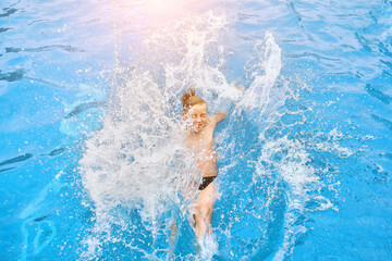 Boy jump, swim in the pool, sunbathes, swimming in hot summer day. Relax, Travel, Holidays, Freedom concept. 