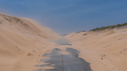 The road between the beautiful white sand dunes in Tarifa. The Valdevaqueros dune, located in the south of Spain, associated with strong easterly winds blowing in the Strait of Gibraltar.