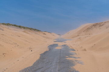 The road between the beautiful white sand dunes in Tarifa. The Valdevaqueros dune, located in the south of Spain, associated with strong easterly winds blowing in the Strait of Gibraltar.