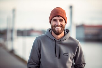 Medium shot portrait photography of a happy boy in his 30s wearing a comfortable hoodie against a picturesque harbor background. With generative AI technology