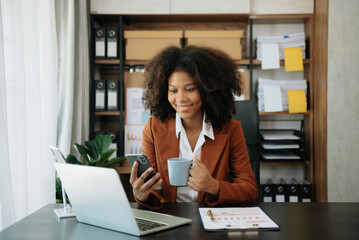 Fototapeta premium Confident business expert attractive smiling young woman typing laptop ang holding digital tablet on desk in creative office..