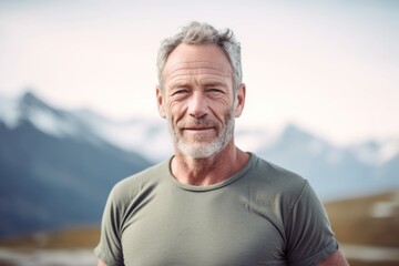 Fototapeta na wymiar Medium shot portrait photography of a tender mature man wearing a casual t-shirt against a serene snow-capped mountain background. With generative AI technology