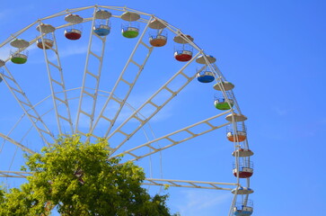 Ferris wheel against the blue sky in a summer park