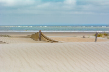 La mer du nord avec ses dunes et ses filets de protection des plages