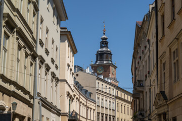 Fototapeta na wymiar Bracka Street in the Old Town district of Krakow, Poland. View from Franciszkańska towards the Cracow Main Square Market. Town Hall Tower or Wieża Ratuszowa Kraków in background.
