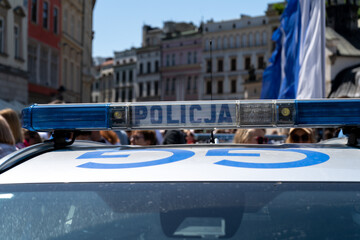 Police car lightbar emergency lights. Letters in Polish language, Policja means Police. Blue lighting flasher light bar mounted on the roof of a patrol vehicle.