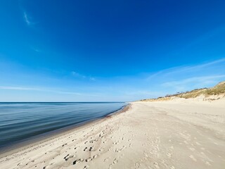 Blue sea horizon and white sandy coastline, wild empty sandy beach, blue sea horizon