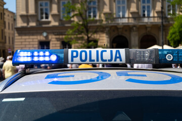 Police car lightbar emergency lights. Letters in Polish language, Policja means Police. Blue lighting flasher light bar mounted on the roof of a patrol vehicle. © Longfin Media