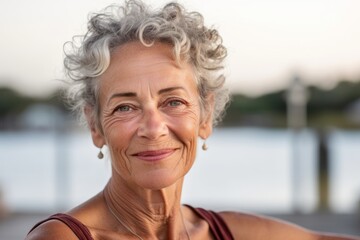 Fototapeta premium Headshot portrait photography of a satisfied mature woman wearing a daring tube top against a scenic lagoon background. With generative AI technology