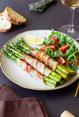 Asparagus baked with bacon and arugula and tomato salad. Healthy eating. Diet.