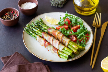 Asparagus baked with bacon and arugula and tomato salad. Healthy eating. Diet.