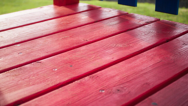 Suelo de tablones de madera pintadas de rojo en parque infantil