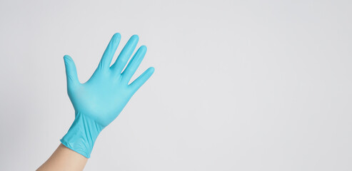 The left hand is wearing blue latex gloves on a white background.