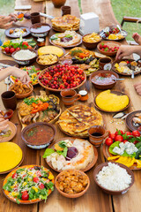 Homemade Romanian Food with grilled meat, polenta and vegetables Platter on camping. Romantic traditional moldavian food outside on the wood table.