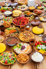 Homemade Romanian Food with grilled meat, polenta and vegetables Platter on camping. Romantic traditional moldavian food outside on the wood table.