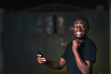 A smiling man holding a cell phone in his hand