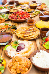 Homemade Romanian Food with grilled meat, polenta and vegetables Platter on camping. Romantic traditional moldavian food outside on the wood table.