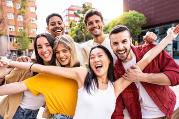 Obraz premium Multiracial best friends having fun outside - Group of young people smiling at camera outdoors - Friendship concept with guys and girls hanging out on city street
