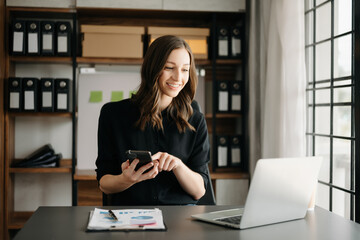 Confident business expert attractive smiling young woman typing laptop ang holding digital tablet...