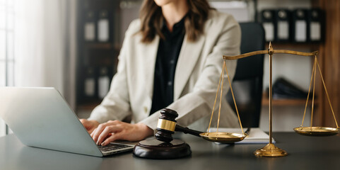 justice and law concept.law theme wooden desk, books, balance. Male judge in a courtroom the gavel,working with digital tablet computer