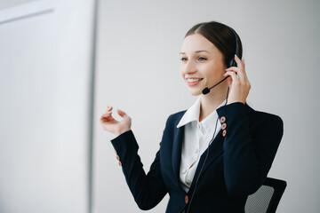 Serious call center operator in wireless headset talking with customer, woman in headphones with...