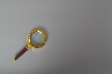 Magnifying glass isolated on a grey background. Copy space for the text.