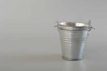 Silver metal bucket isolated on a grey background.