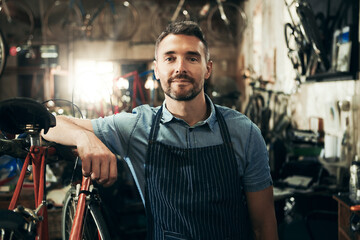 Portrait, serious and repair man in bicycle shop working in store or cycling workshop. Face, bike...