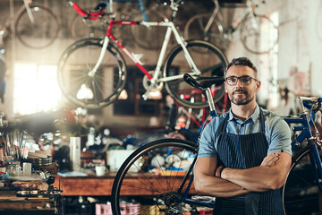 Portrait, serious and repair man in bicycle shop with arms crossed working in workshop. Face, bike...