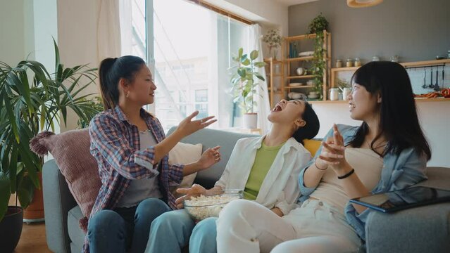 Group of female friends enjoying life and having fun at home. Girls day in the apartment. Young women spending time together chatting and making activities in the living room. Concept about lifestyle
