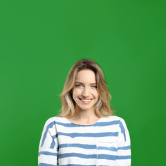 Chroma key compositing. Happy young woman smiling against green screen