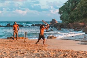 boy playing cricket at sunset on tropical beach in Sri Lanka,asian american, aapi people,national sport