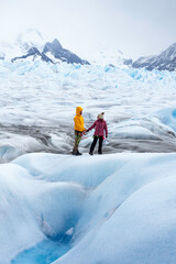 Fototapeta na wymiar Travelers couple in love posing on the ice formation of the Perito Moreno glacier, Argentina
