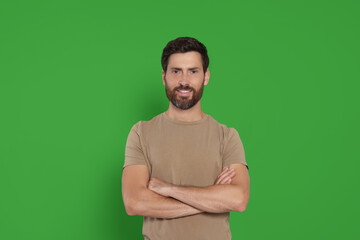 Chroma key compositing. Handsome man smiling against green screen - Powered by Adobe