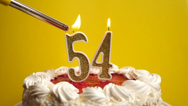 A candle in the form of the number 54 is lit, which is stuck into the holiday cake. Celebrating a birthday or a landmark event. The climax of the celebration.