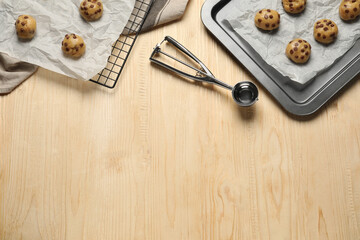Fototapeta na wymiar Uncooked chocolate chip cookies on wooden table, top view. Space for text
