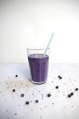 Smoothie glass with blueberry, linen seeds, milk