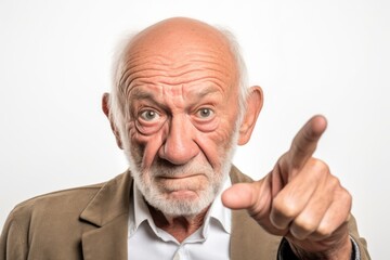Obraz premium Close-up portrait photography of a glad old man making a gesture of i'm thinking with the finger on the head against a white background. With generative AI technology