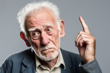 Close-up portrait photography of a glad old man making a gesture of i'm thinking with the finger on the head against a white background. With generative AI technology