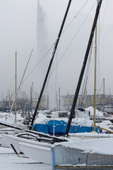 Bateaux de plaisance couverts de neige dans la rade de Gen&egrave;ve en hiver